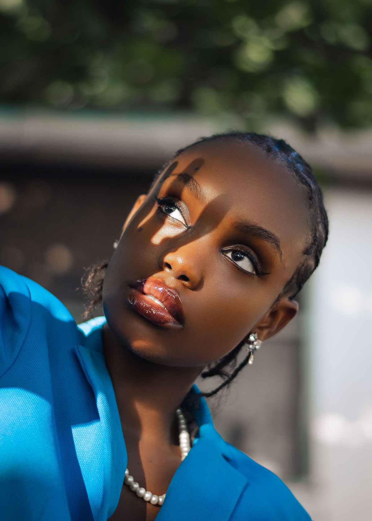 A woman in a vivid blue blazer, with sunlight across her face