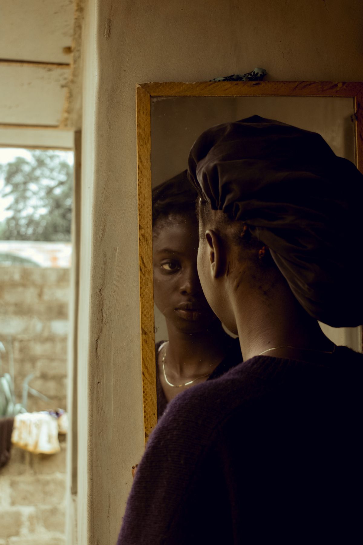 A woman looking at her reflection in a vintage mirror